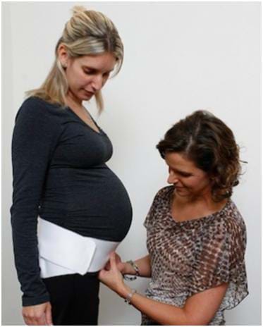 pregnant women getting fitted with belt